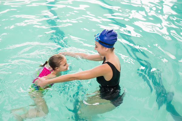 15520744_cute-little-girl-learning-to-swim-with-coach
