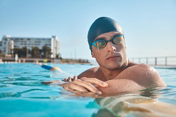 Real athletes swim, the rest play games. a young man going for a swim in an olympic pool