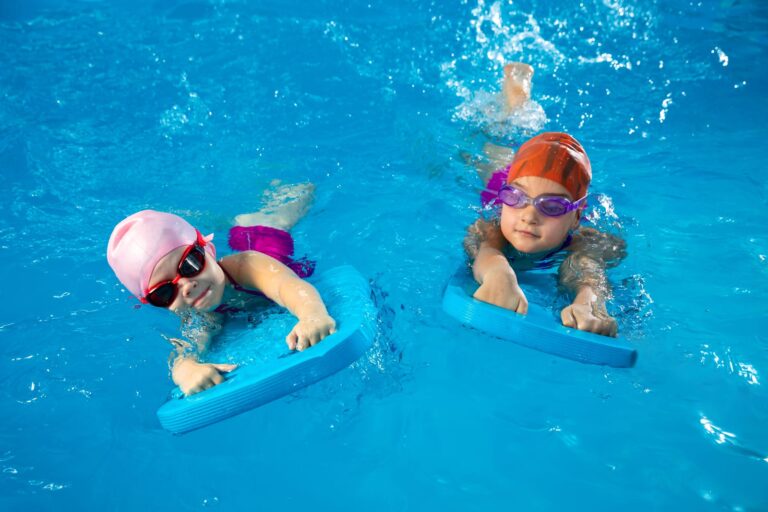 52111760_two-little-kids-learning-how-to-swim-in-swimming-pool-using-flutter-boards